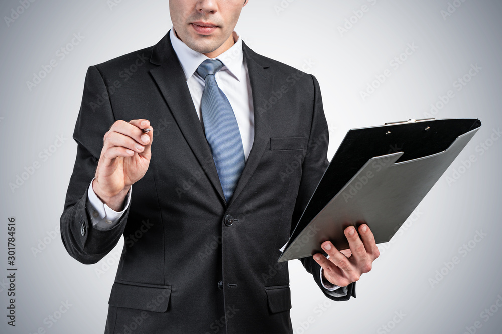 Close up of businessman with clipboard, gray Close up of businessman with clipboard, gray