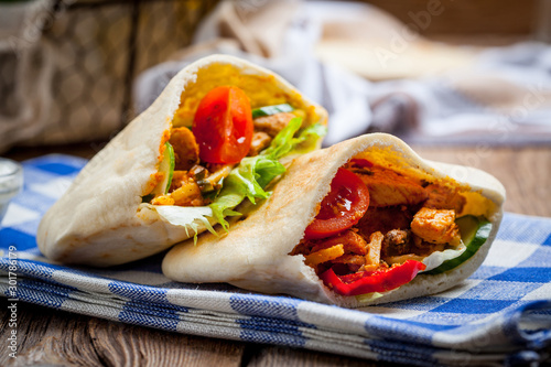 Fotografie Fried chicken meat with vegetables in pita bread
