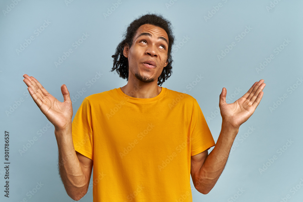 Black man screaming in shock and amazement, can't believe his luck on blue wall Black man screaming in shock and amazement, can't believe his luck on blue wall