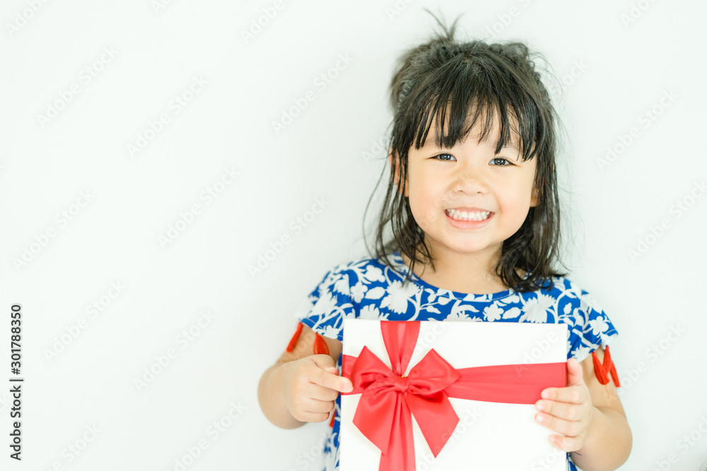 Little asian girl smile and holding red gift box on white background.child holding gift box. Little asian girl smile and holding red gift box on white background.child holding gift box.