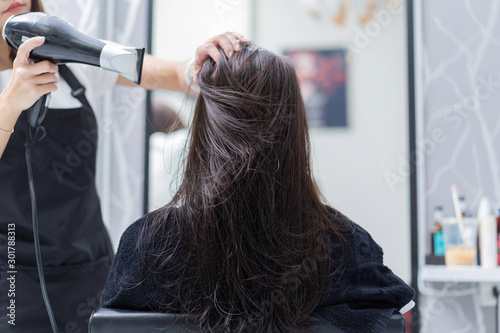 Beautician doing hair for customers She is a beautiful woman in a salon