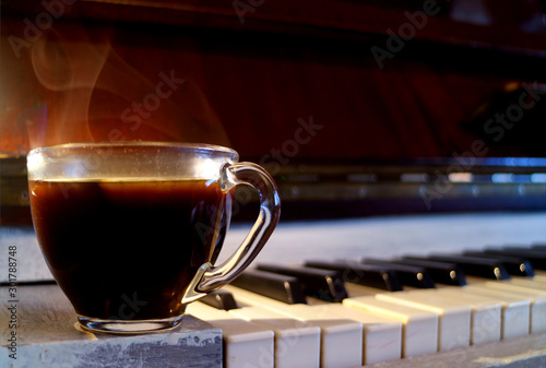 Canvas Print Closeup a cup of hot coffee with smoke on the piano