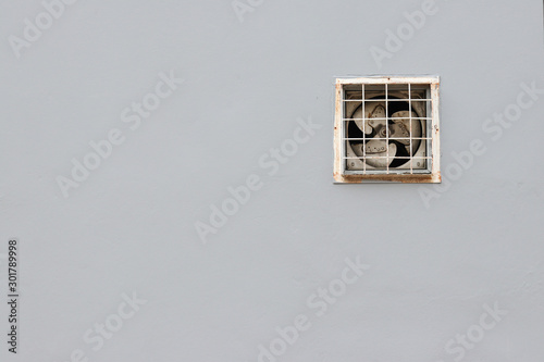 Ventilating fan installed on a gray wall. 