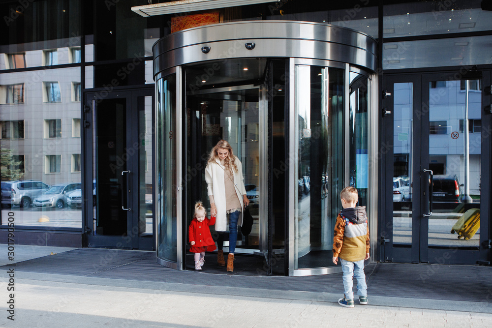 Fototapeta premium Mother with two children at the entrance.