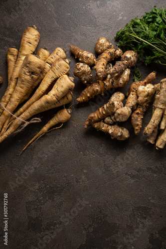 Fresh and organic roots on dark background top view