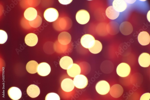 Many soft orange, red and yellow blurry bokeh light on dark red background in Christmas and New Year festival day, can use for background
