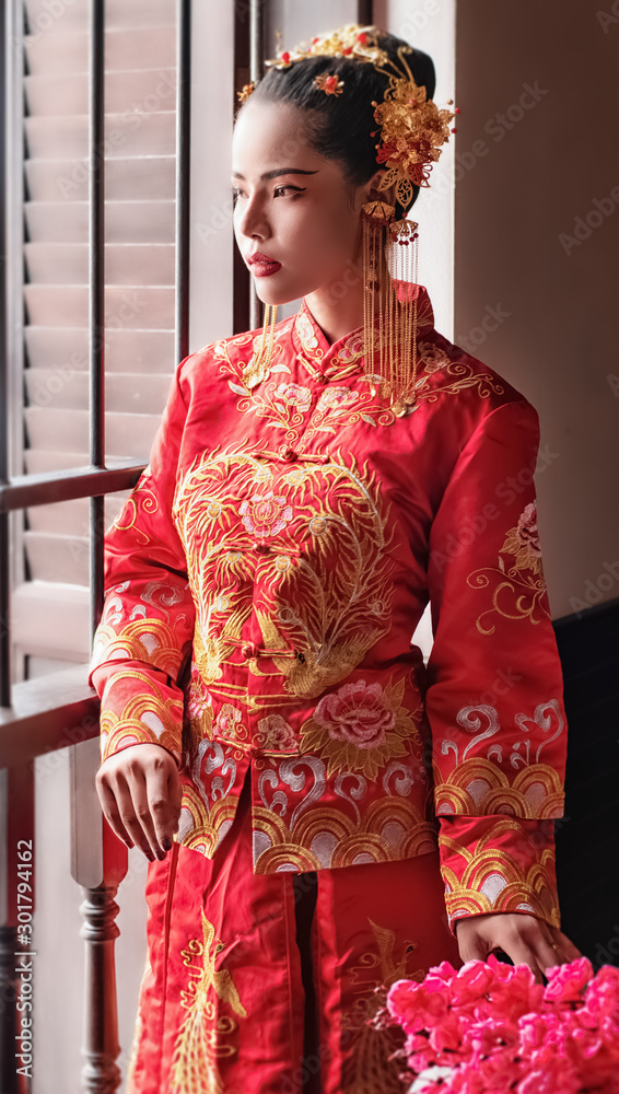 The beautiful woman wearing red dress standing beside window,looking straight,portrait of model posing ,Chinese New Year festival The beautiful woman wearing red dress standing beside window,looking straight,portrait of model posing ,Chinese New Year festival