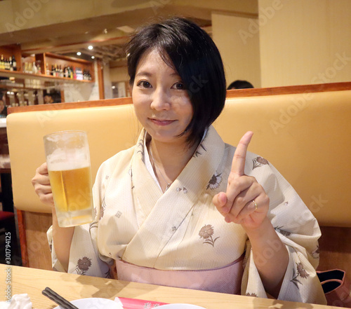 美味しいビールを飲む着物の女性
