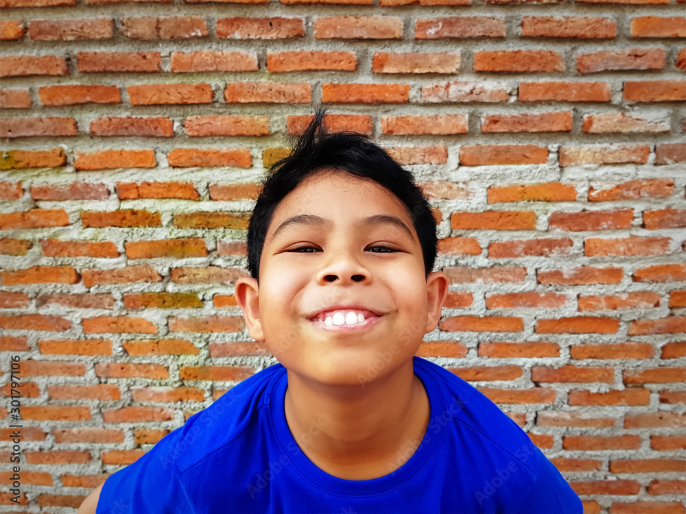 Asian Boy in Blue Casual Clothing Smiling Showing Teeth Asian Boy in Blue Casual Clothing Smiling Showing Teeth