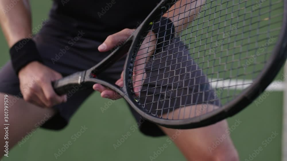 Close up of a tennis player ready to return with his racket. Pro tennis player with his racket during a match.