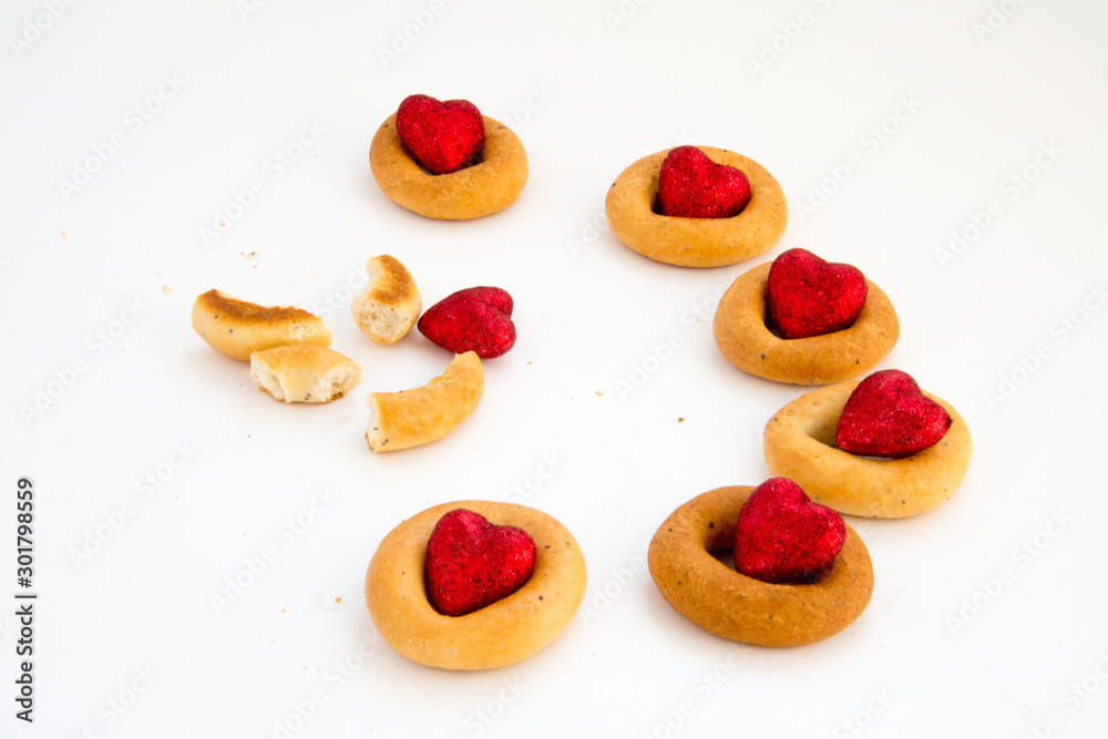Bread rings on a white background in combination with red hearts. Love and friendship. Loneliness, misunderstanding.The concept of Valentine Day