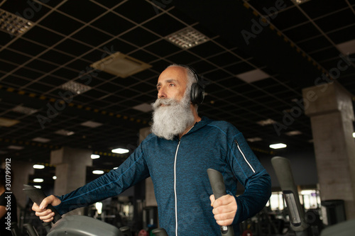 Bearded Senior Man On Running Machine In Gym. Treadmill. 