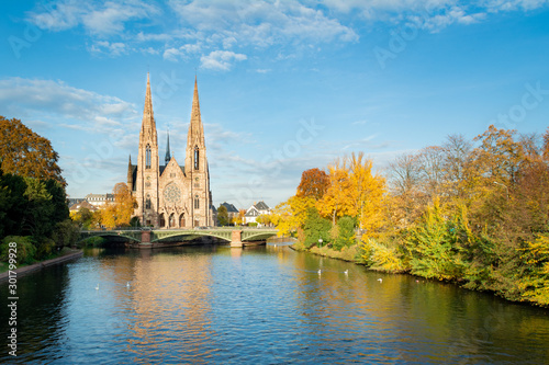 Cityscape autumnal view, of Ill River in Strasbourg, and the Saint Peter cathedral on the background.