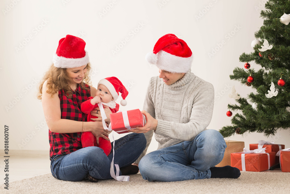 Happy couple with baby celebrating Christmas together at home. Happy couple with baby celebrating Christmas together at home.