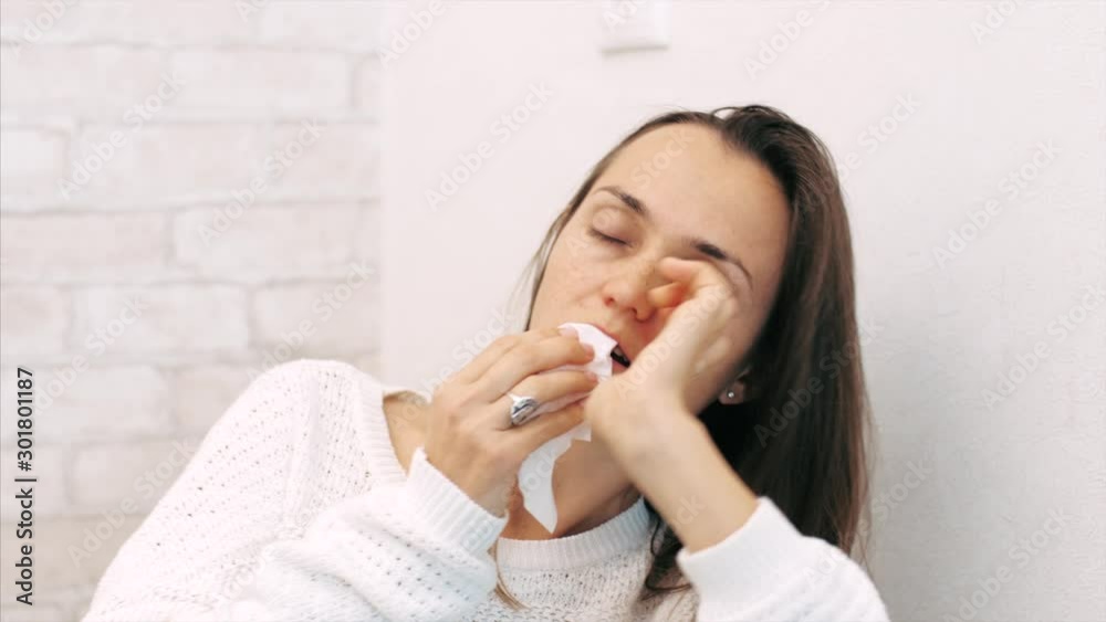 Close-up portrait of illness young woman sneezing and coughing in paper napkin. Close-up portrait of illness young woman sneezing and coughing in paper napkin.