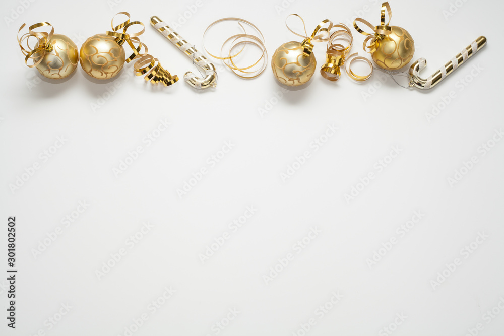 Christmas background for text is white, decorated with gold Christmas tree toys, gold ribbons and candies. The concept of a New year or Christmas. Christmas background for text is white, decorated with gold Christmas tree toys, gold ribbons and candies. The concept of a New year or Christmas.
