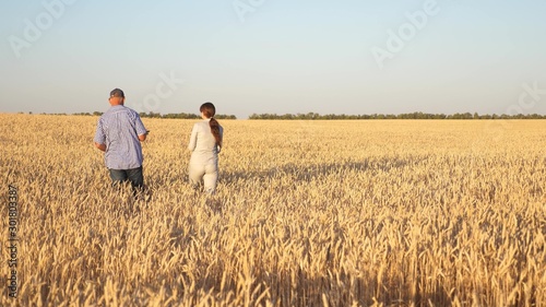 Happy businessmen farmers discuss wheat crop on the field. Ripening grain and harvesting. Agronomists checks the quality of wheat. Agriculture concept. Business colleagues.