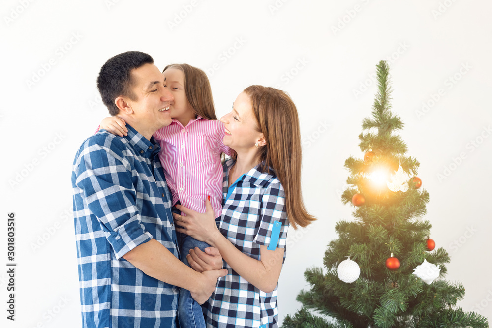Holidays, gifts and christmas tree concept - Small family having happy time together on Christmas. Holidays, gifts and christmas tree concept - Small family having happy time together on Christmas.