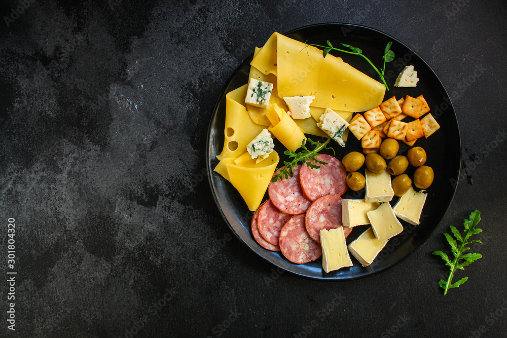 cheese board (different types of cheese plate appetizers , sausage, ham, olives, greens and more) menu concept. food background. copy space. Top view