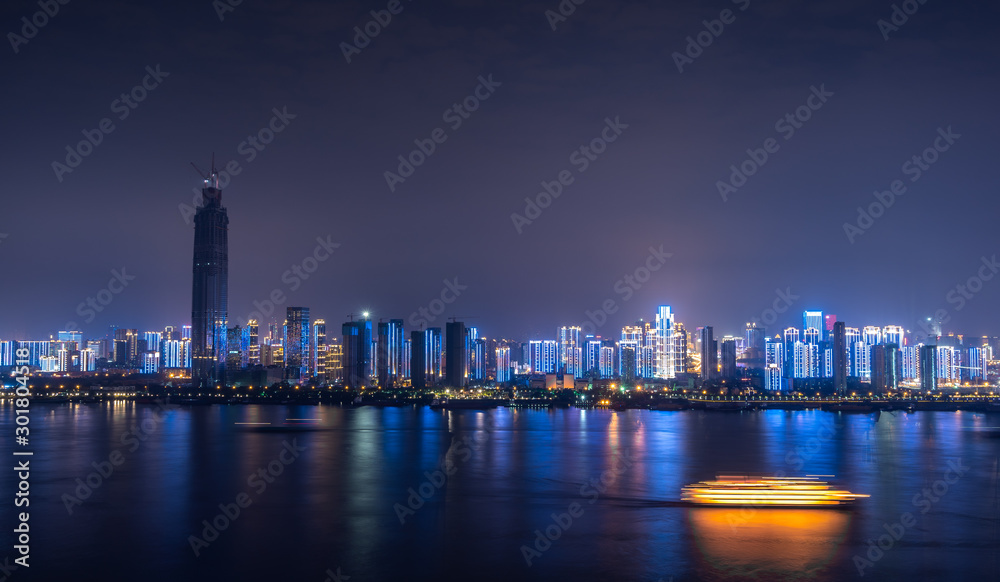 Cityscape of Wuhan city at night, night lights and road traffic along the streets beside yangtze river.