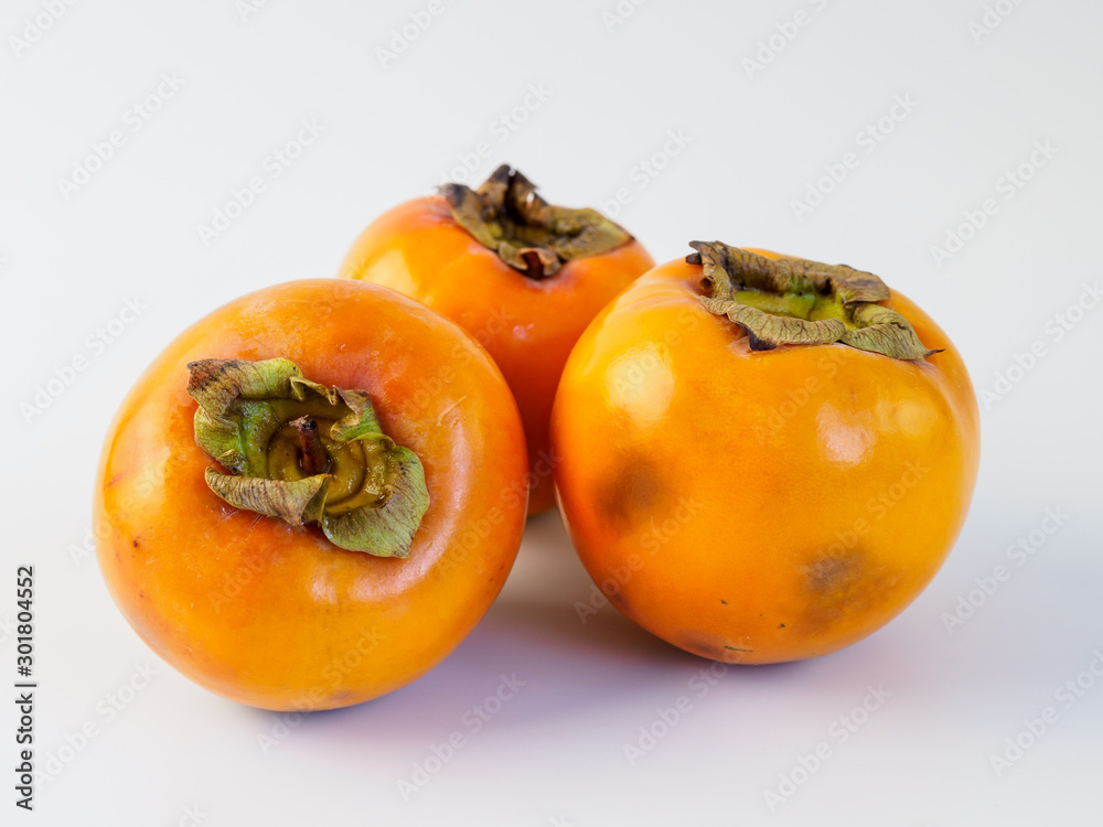 Three persimmon isolated on white background. Three persimmon isolated on white background.