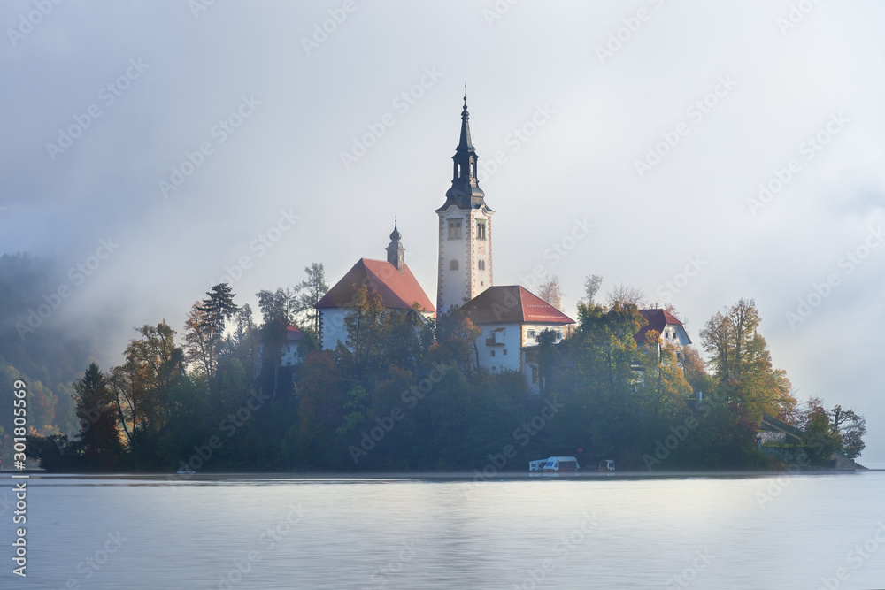 The Pilgrimage Church of the Assumption of Maria on lake Bled on a foggy hazy morning