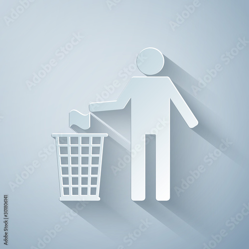 Paper cut Man throwing trash into dust bin icon isolated on grey background. Recycle symbol. Paper art style. Vector Illustration