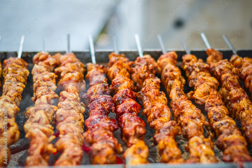 Selective focus, chicken kebabs cooking on a charcoal grill at Christmas market winter wonderland in London