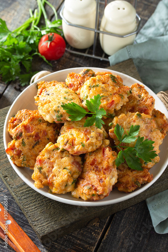 Chicken meatballs with minced meat with tomatoes in a bowl on a wooden rustic table.