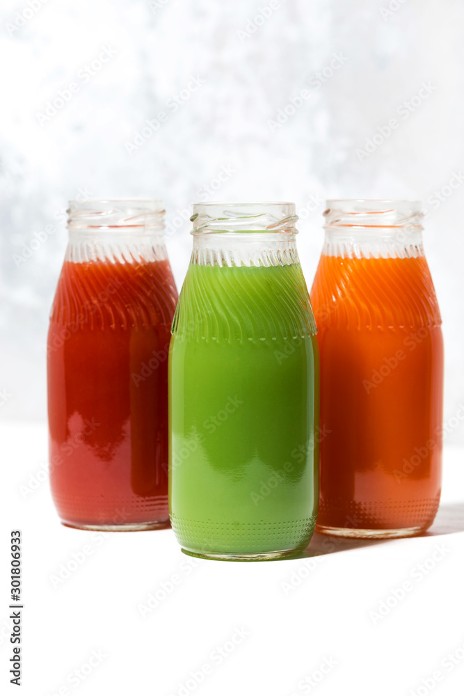 colorful vegetable juices in bottles, vertical closeup colorful vegetable juices in bottles, vertical closeup