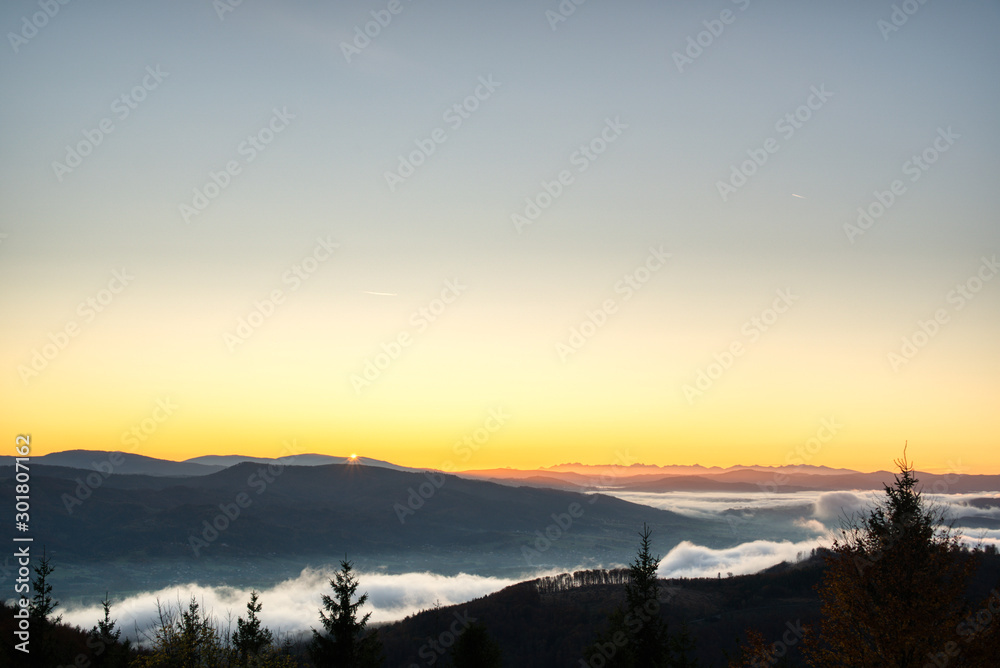 sunrise over mountains with fog in valley