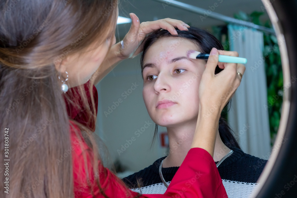 Fototapeta premium Young girl masks pimples in beauty salon