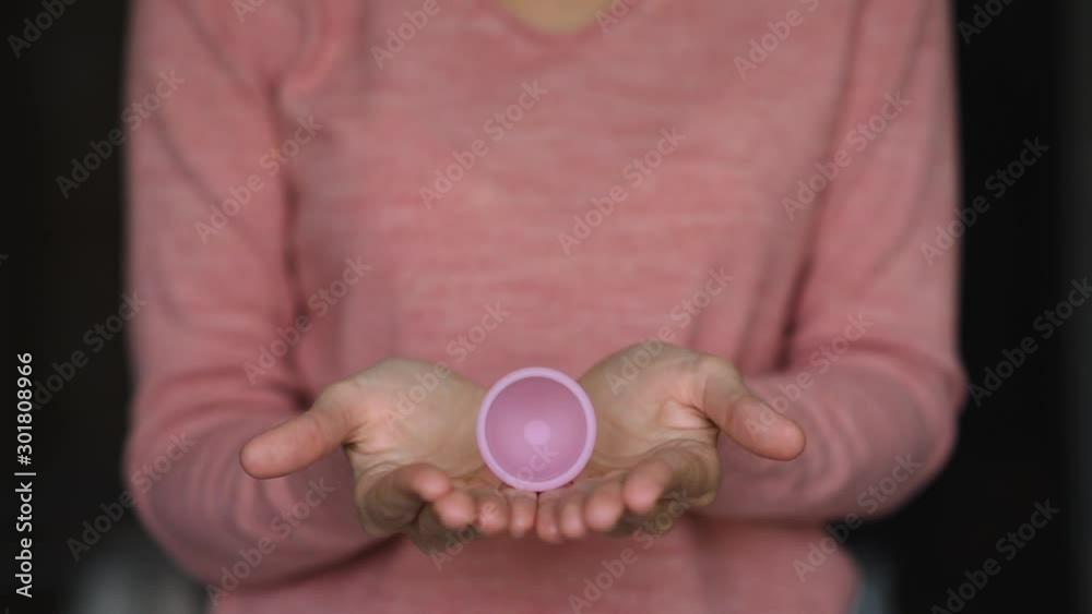 Woman hold a pink mestrual up in her hands. Woman health concept Woman hold a pink mestrual up in her hands. Woman health concept