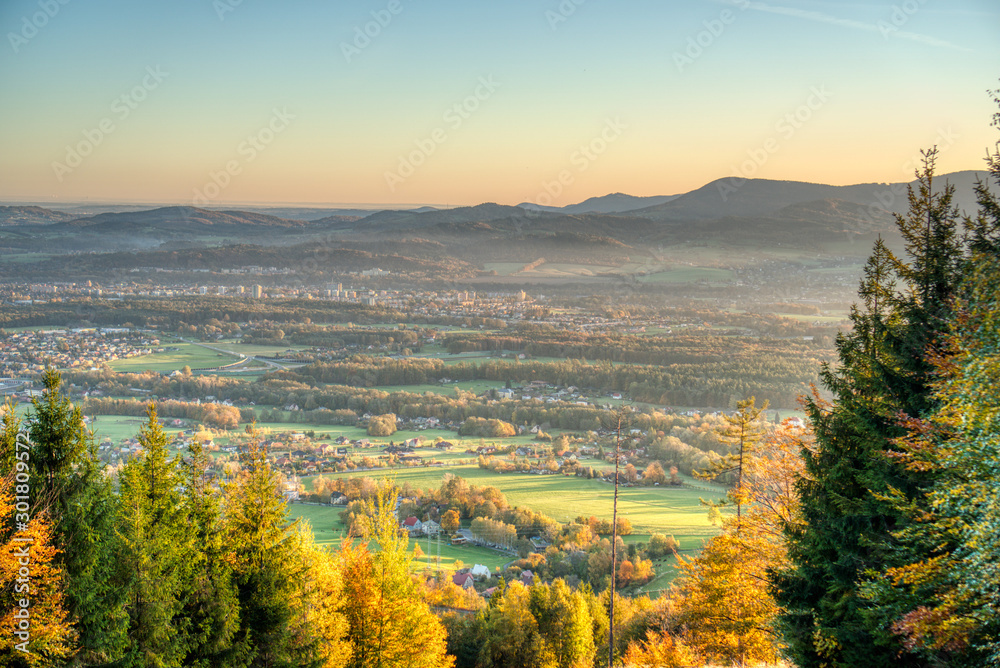 view of a valley full of industry that smokes and house from the mountain at sunrise in autumn