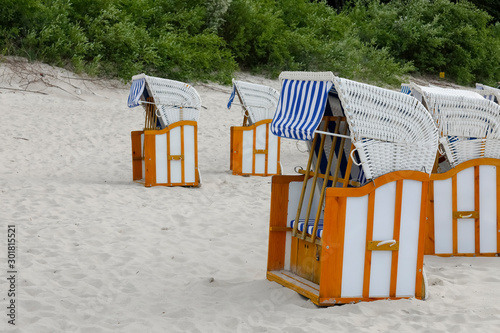 Roofed beach armchairs in the shape of a booth