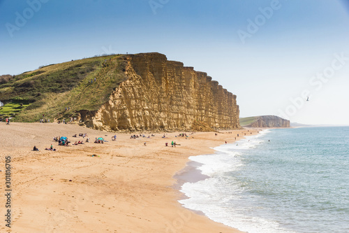 Dramatic layered cliffs of Bridport sandstone along the west Dorset Jurassic coast with Chesil beach disappearing in to the background photo