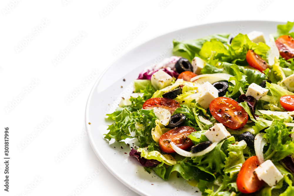 Fresh greek salad on a plate on white background