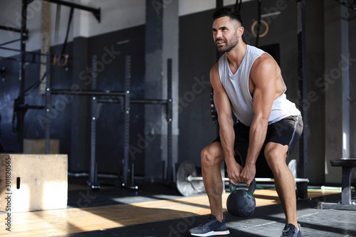 Konstfotografi Fit and muscular man focused on lifting a dumbbell during an exercise class in a gym
