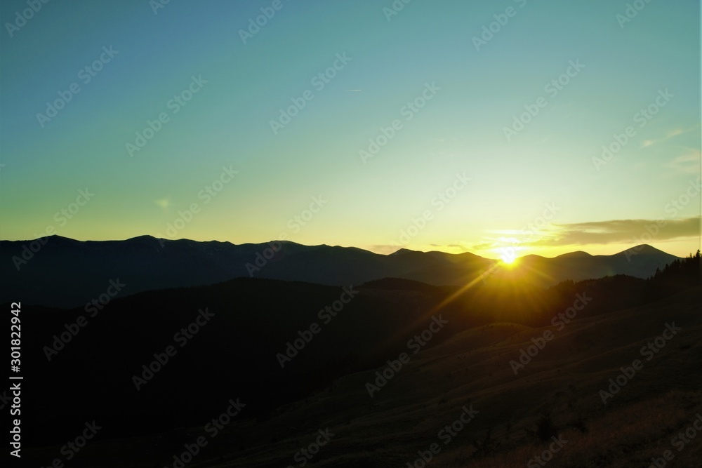  the rays of the setting sun over the mountains
