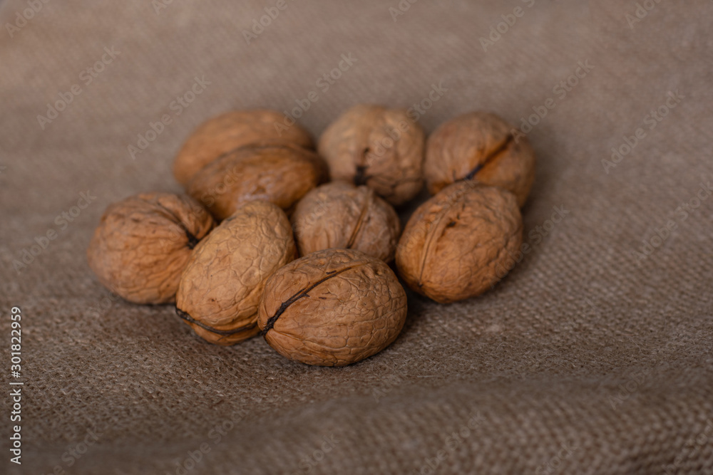 a bunch of whole unpeeled walnuts lie on a linen cloth a bunch of whole unpeeled walnuts lie on a linen cloth