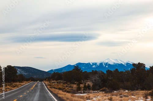 Amazing winter scenery, empty expressway US 89 N towards, Flagstaff, AZ, Snow covered San Francisco peak at the backdrop with awesome lenticular clouds over the mountains. Long drive/road trip travel  photo