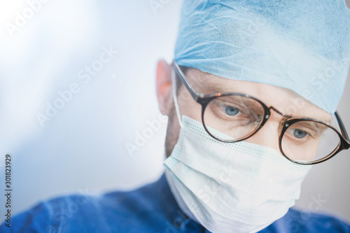 bottom view of a young surgeon looking at camera. Surgical operation in the hospital.