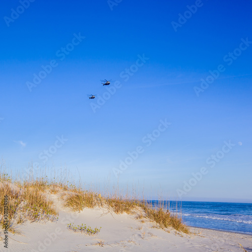 Dunes with helicopters in sky