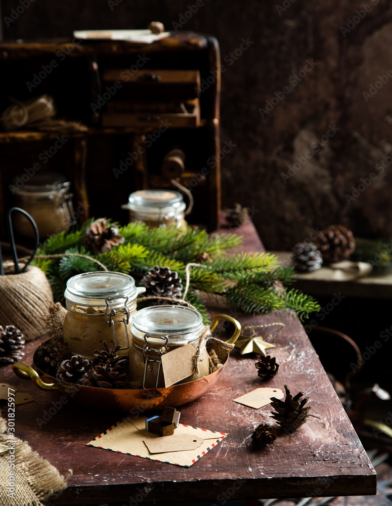 homemade liver pate in glass jars on rustic table with fir tree branches, toys