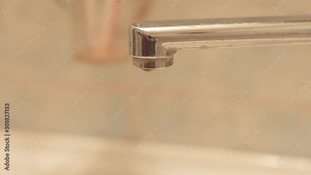 Water dripping from tap close-up, concept, save water and natural resources. Water dripping from tap close-up, concept, save water and natural resources.