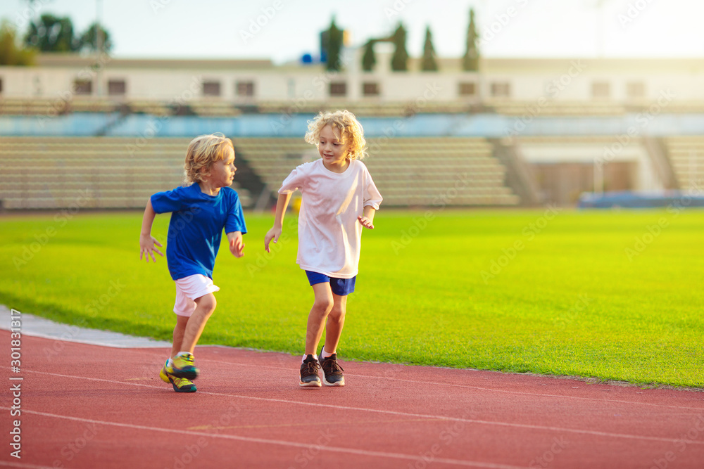 Fototapeta premium Child running in stadium. Kids run. Healthy sport.