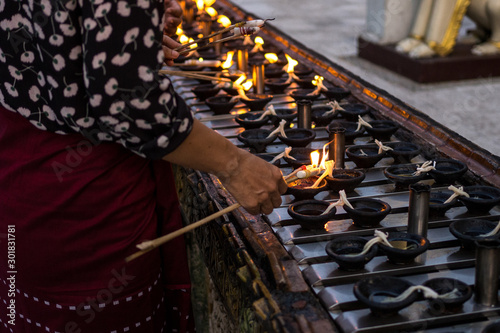 Yangon / Myanmar - August 2019: Lighting candles at shwedagon pegoda