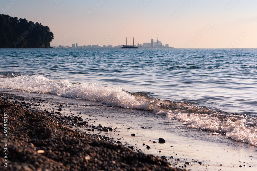Panoramic skyline view on the Black sea with waves and ship and far buildings on the coast of the Black sea. Panoramic skyline view on the Black sea with waves and ship and far buildings on the coast of the Black sea.