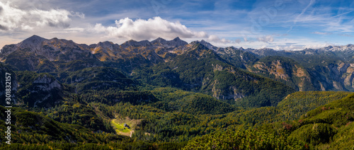 Mountain range panoramic landscape view with mountain cottage in the distance, near Lake Bohinj, Slovenia