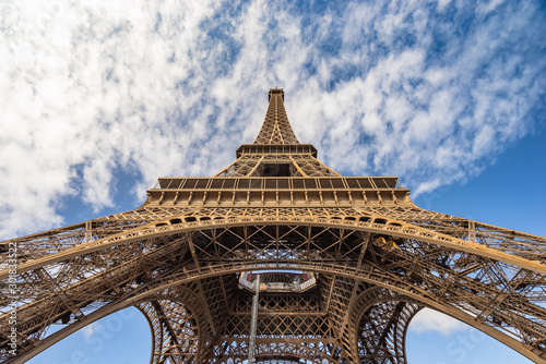 Eiffel Tower in Paris frog view with blue sky and clouds
